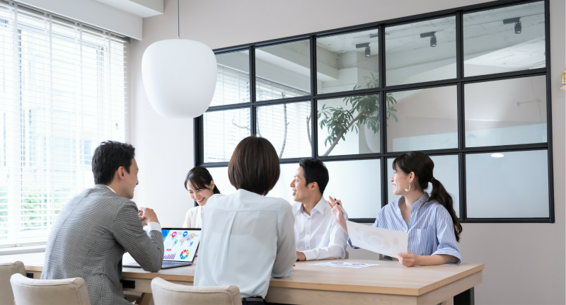 複数のスタッフがタブレットを見ながら真剣にミーティングをしている様子